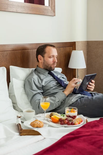 Affärsman med tablett under frukost — Stockfoto