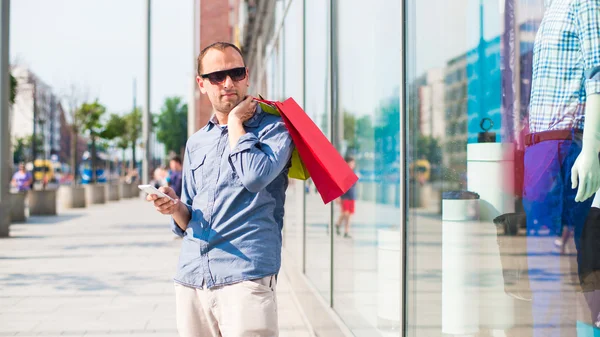 Muž s nákupní tašky a telefon — Stock fotografie