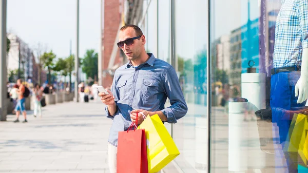 adam alışveriş torbaları ve telefon