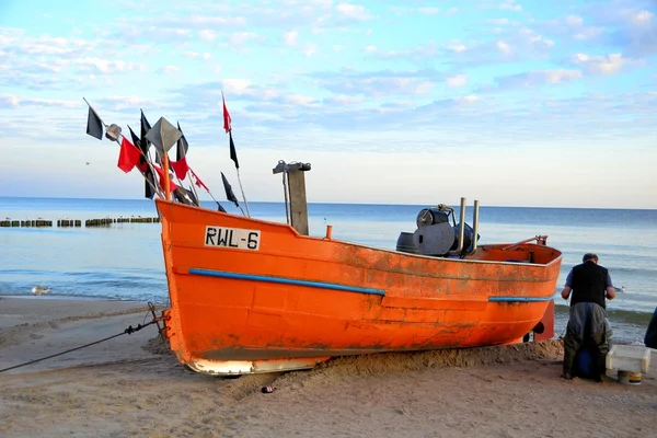 Um barco de pesca com um pescador na costa do Báltico — Fotografia de Stock