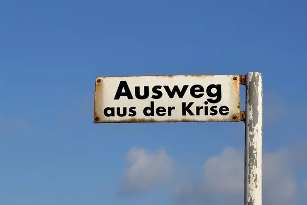 An old street sign with the words out of the crisis — Stock Photo, Image