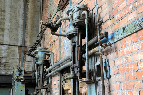 Трубы и арматура на заброшенном заводе — стоковое фото