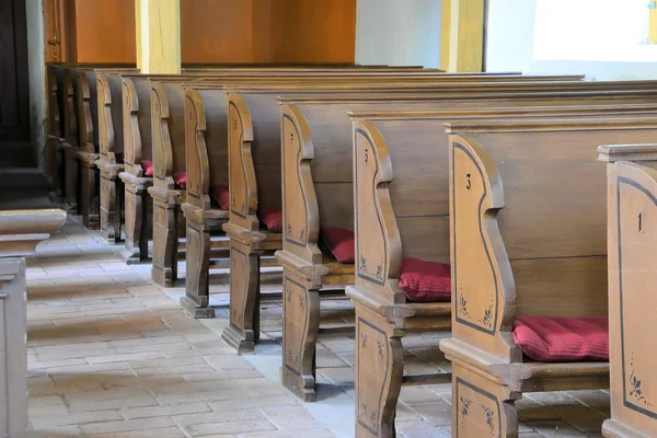 Houten bankjes in een dorpskerk — Stockfoto