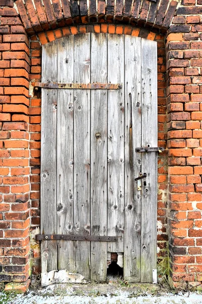 Uma porta de madeira velha em um edifício de fábrica desutilizado — Fotografia de Stock