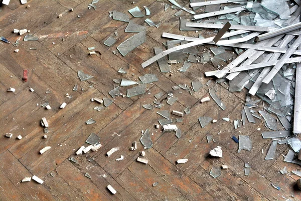 寄せ木張りの床にガラスの破片 — ストック写真