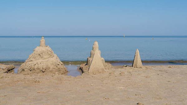 Песчаные замки на пляже Колобжег на польском побережье Балтийского моря летом                               