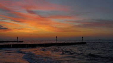 Polonya Baltık sahilindeki Kolobrzeg sahilinde gün batımından sonra parlayan gökyüzü                               
