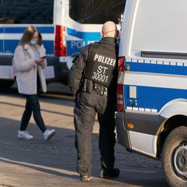   Magdeburg, Germany  January 08, 2022: Police officer in downtown Magdeburg in Germany takes a break and is bored                             