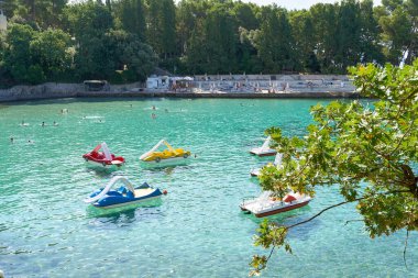 Krk, Hırvatistan 3 Ağustos 2021: Hırvatistan 'ın Krk kenti yakınlarındaki Adriyatik Denizi kıyısında pedallı teknelerle banyo yapmak 