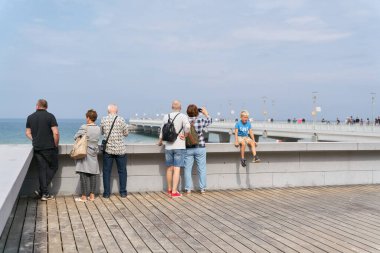   Kolobrzeg, Polonya, 11 Eylül 2021: Polonya Baltık kıyısındaki Kolobrzeg deniz gezisinde tatilciler. Arka planda iskele var..                             