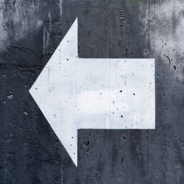  Beton bir duvarda oryantasyon için siyah arkaplan üzerinde beyaz yönlü ok                              