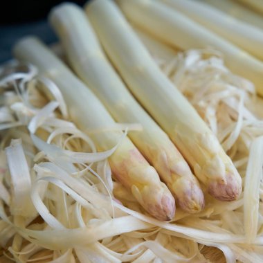   Mutfak masasında soyulmuş beyaz kuşkonmaz.                             