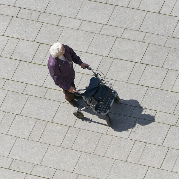    Magdeburg, Germany  April 29, 2022: an old woman with a walker walking through the city                            