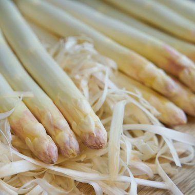  Mutfak masasında soyulmuş beyaz kuşkonmaz.                              