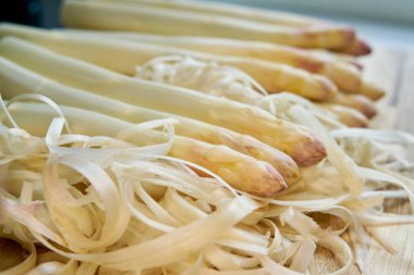  Mutfak masasının üstündeki tarladan taze soyulmuş beyaz kuşkonmaz.                              