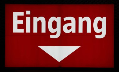 illuminated red sign at the entrance to a store in Germany. Translation: entrance                               