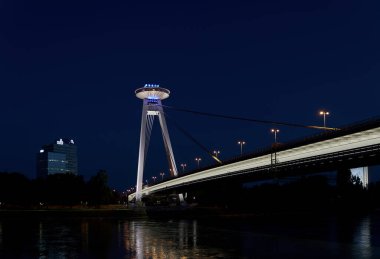Bratislava, Slovakia  June 19, 2022: The bridge of the Slovak National Uprising in Bratislava SNP over the Danube River in the evening with a restaurant at a great height                               