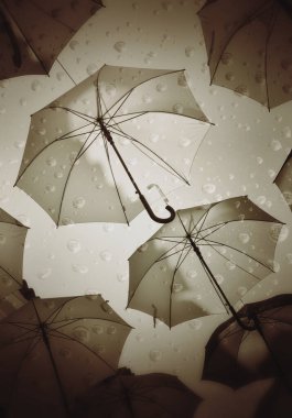 Superimposed images of raindrops and umbrellas as a representation of bad weather