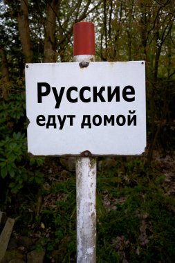  Sign in Russian language in a forest with the inscription Russians go home                              