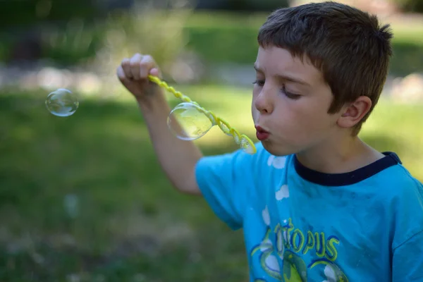 Boy blowing bubbles — Stock Photo, Image