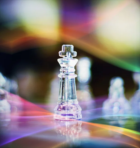 Rei peça de xadrez de vidro contra fundo colorido — Fotografia de Stock