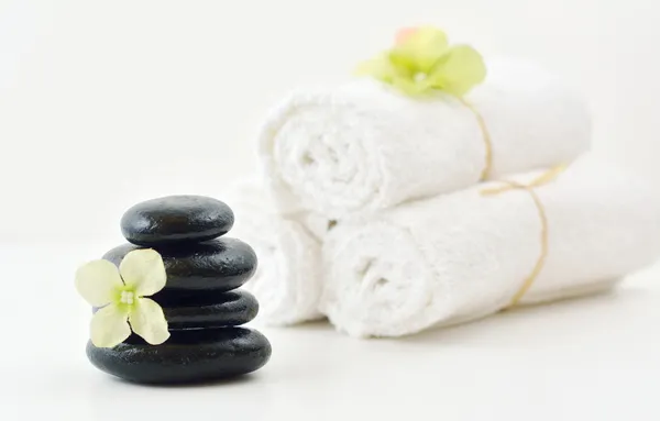 Wellness stones, bloem, & witte towels handdoeken — Stockfoto