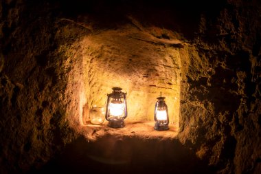 Geceleyin eski bir şatonun harabelerinde gaz lambası yanıyor.