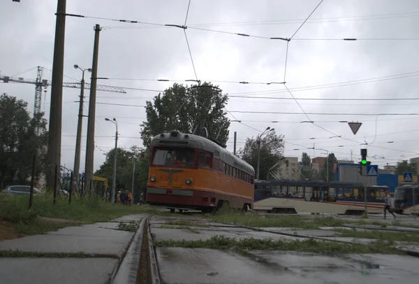 Old and new tram in cloudy weather