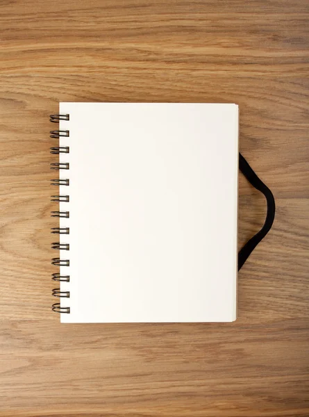 Tom spiral notebook på en trä bakgrund med urklippsbana. — Stockfoto