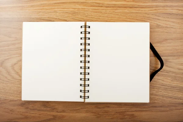 Opened notebook with black elastic band a table. — Stock Photo, Image