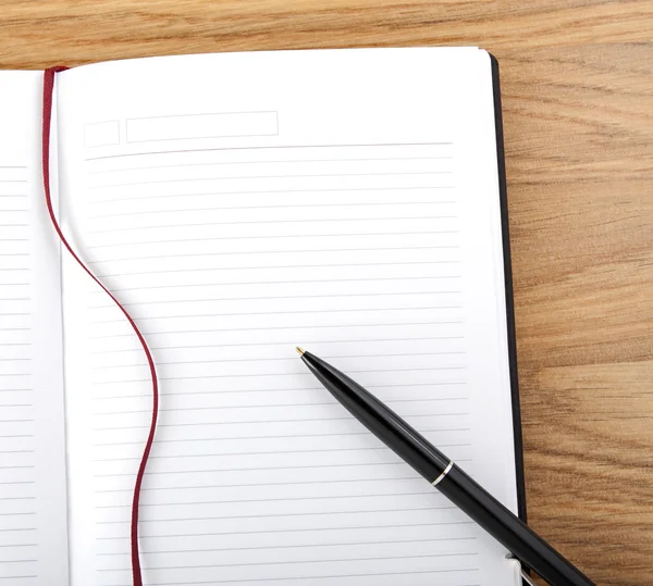 Open boek met blanke pagina met lijnen, rode bladwijzer, zwarte dekking en pen. — Stockfoto