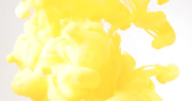 Sarı mürekkep suyun içine karışıyor. Suyun altında yavaşça dönüyor.