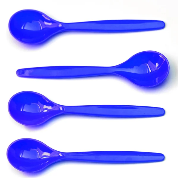 Four blue teaspoons, one against the mainstream — Stock Photo, Image
