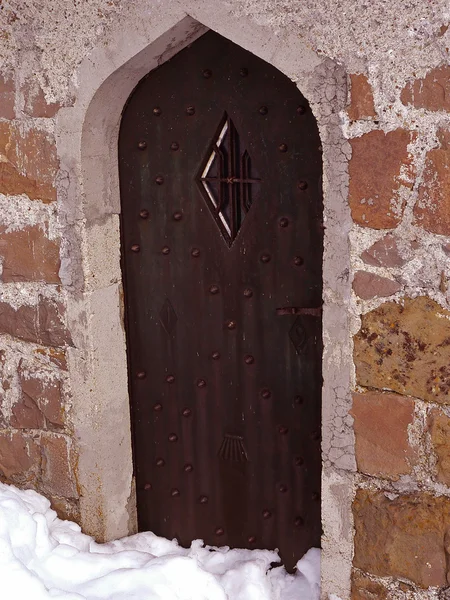 Gamla välvda kyrkliga dörren på vintern — Stockfoto
