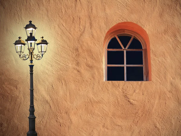 Фасад средиземноморского дома с мрачным фонарем и арочным окном — стоковое фото