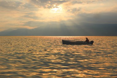 Fishing boat at garda lake, romantic mood clipart