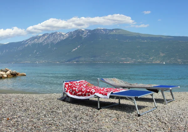 Sun loungers at garda lake shore — Stock Photo, Image