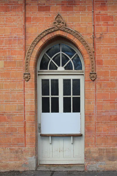 Fachada de ladrillo rojo con puerta arqueada, estilo vintage — Foto de Stock