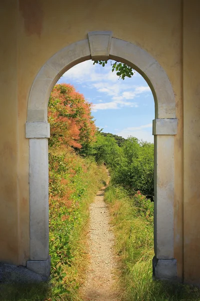 Passerelle à travers la vieille porte voûtée, paysage printanier méditerranéen — Photo