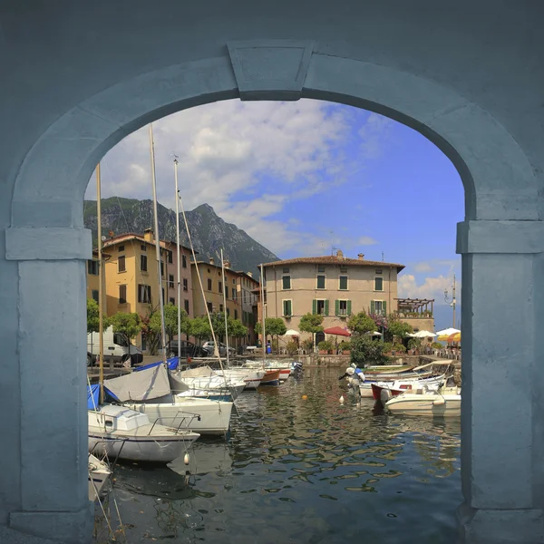 View through arched vintage door to picturesque harbor with sailboats — Stock Photo, Image