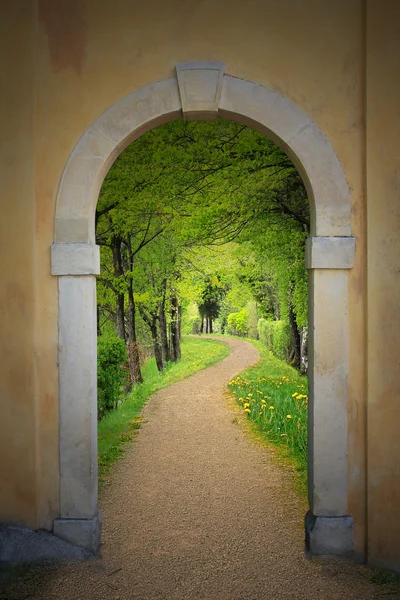 Walkway through arched old door — Stock Photo, Image