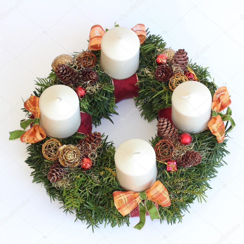 handmade advent wreath with white candles, cones, orange ribbons