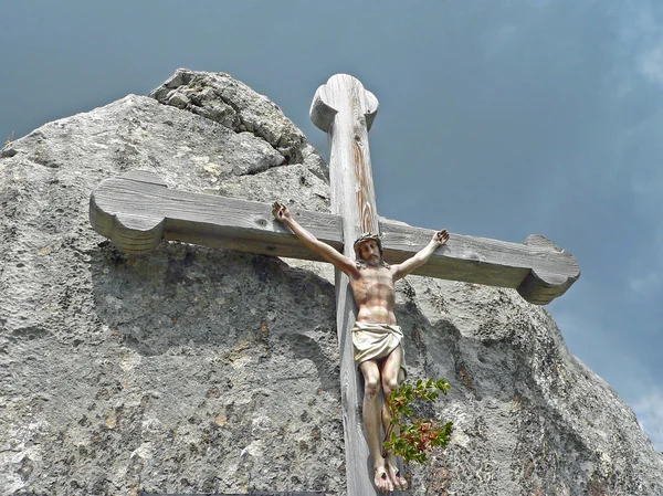 Cruz de madeira nas montanhas com corpo de Jesus, contra dramático — Fotografia de Stock