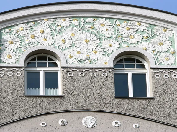 Исторический фасад штукатурки с окнами и декоративными цветочными лепестками — стоковое фото