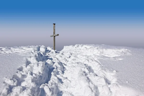 Sentier de montagne hivernal et croix du sommet, contre le ciel bleu — Photo