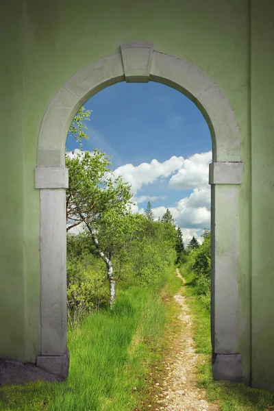 Caminho pela porta arqueada em glândula bovina selvagem, terras da primavera — Fotografia de Stock