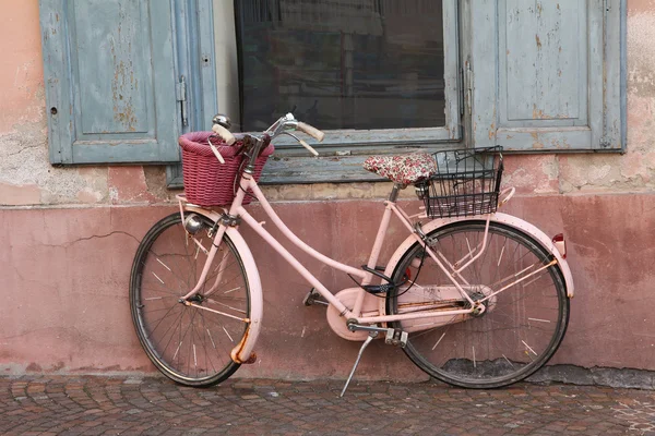 Ностальгический розовый велосипед против фасада дома — стоковое фото