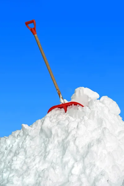 Grande pilha de neve e pá, céu azul — Fotografia de Stock