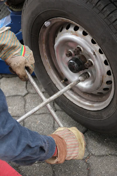 Mann wechselt Autoreifen — Stockfoto