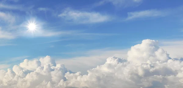 Blauer Himmel mit aufgetürmten Wolken und strahlender Sonne — Stockfoto